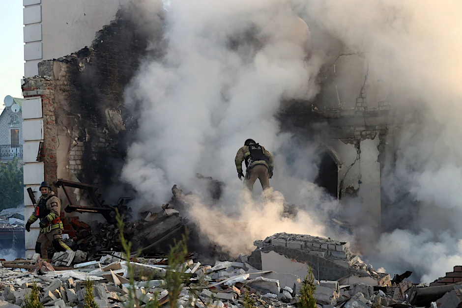 Nach russischem Beschuss steht ein Feuerwehrmann in Charkiw im Qualm eines brennenden Hauses.
