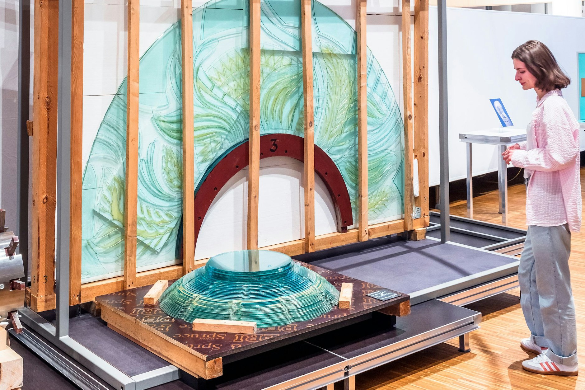 Es war einmal eine Gläserne Blume; es blieben Fragmente: erstmals wieder in der Öffentlichkeit zu sehen – ein Blütenblatt im Transportrahmen und ein Teil der grün-gläsernen Innenkugel. Links außerhalb des Bildes liegt der Schaft aus Edelstahl.