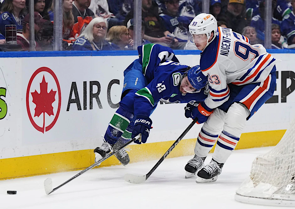 Quinn Hughes von den Vancouver Canucks wird von Ryan Nugent-Hopkins von den Edmonton Oilers zu Fall gebracht.  ia AP/dpa