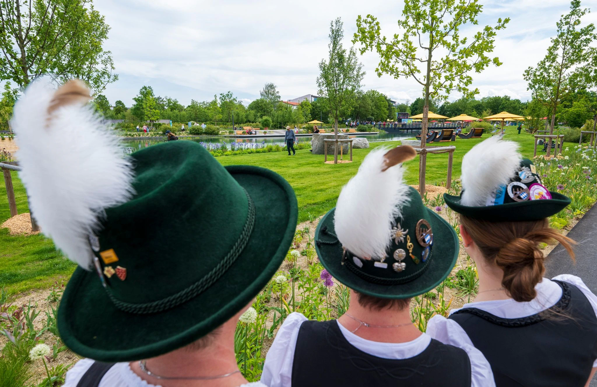 Wiesen, Wasser, Wildnis auf fast 14 Hektar Fläche: Besucherinnen in Tracht werfen einen Blick auf das Gelände der frisch eröffneten Bayerischen Landesgartenschau 2024 in Kirchheim.  