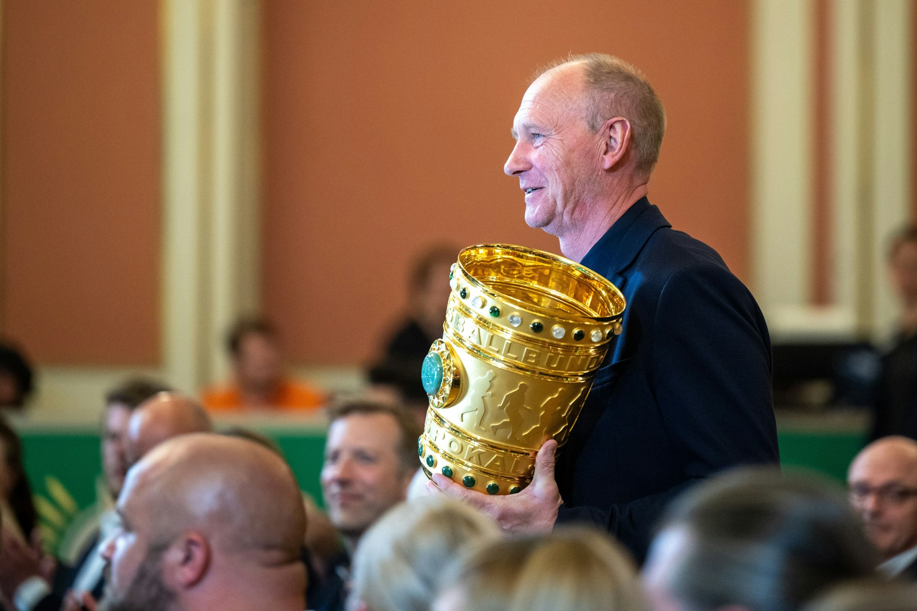 Perry Bräutigam, Clubrepräsentant des RB Leipzig, trägt den DFB-Pokal am 13. Mai bei einer Veranstaltung im Roten Rathaus anlässlich der Übergabe des Pokals vor dem 81. Finale.
