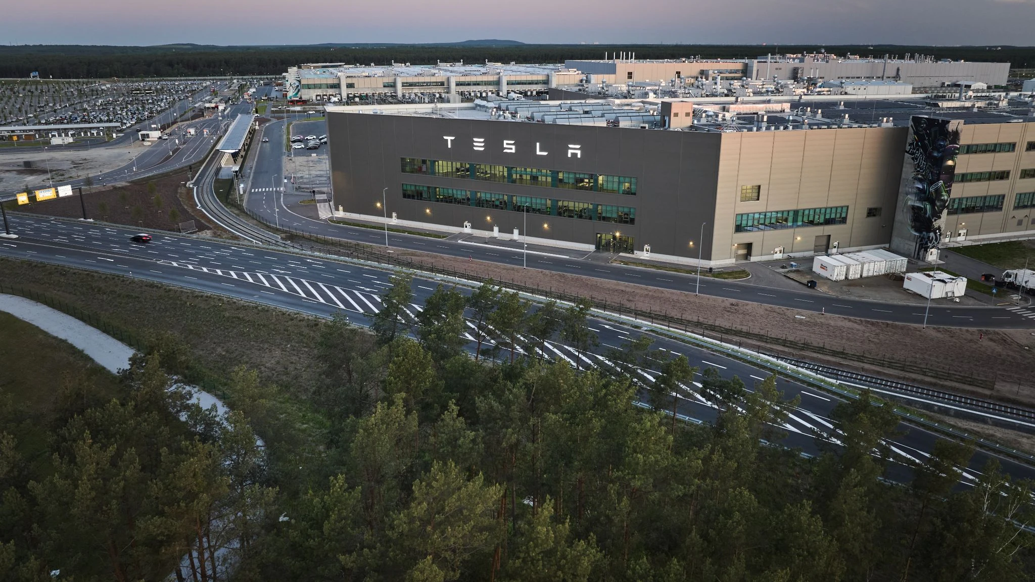 Blick am frühen Morgen auf das Tesla-Werk: Begleitet von Protest stimmt die Gemeinde Grünheide heute über Ausbaupläne des Elektroautobauers Tesla ab.