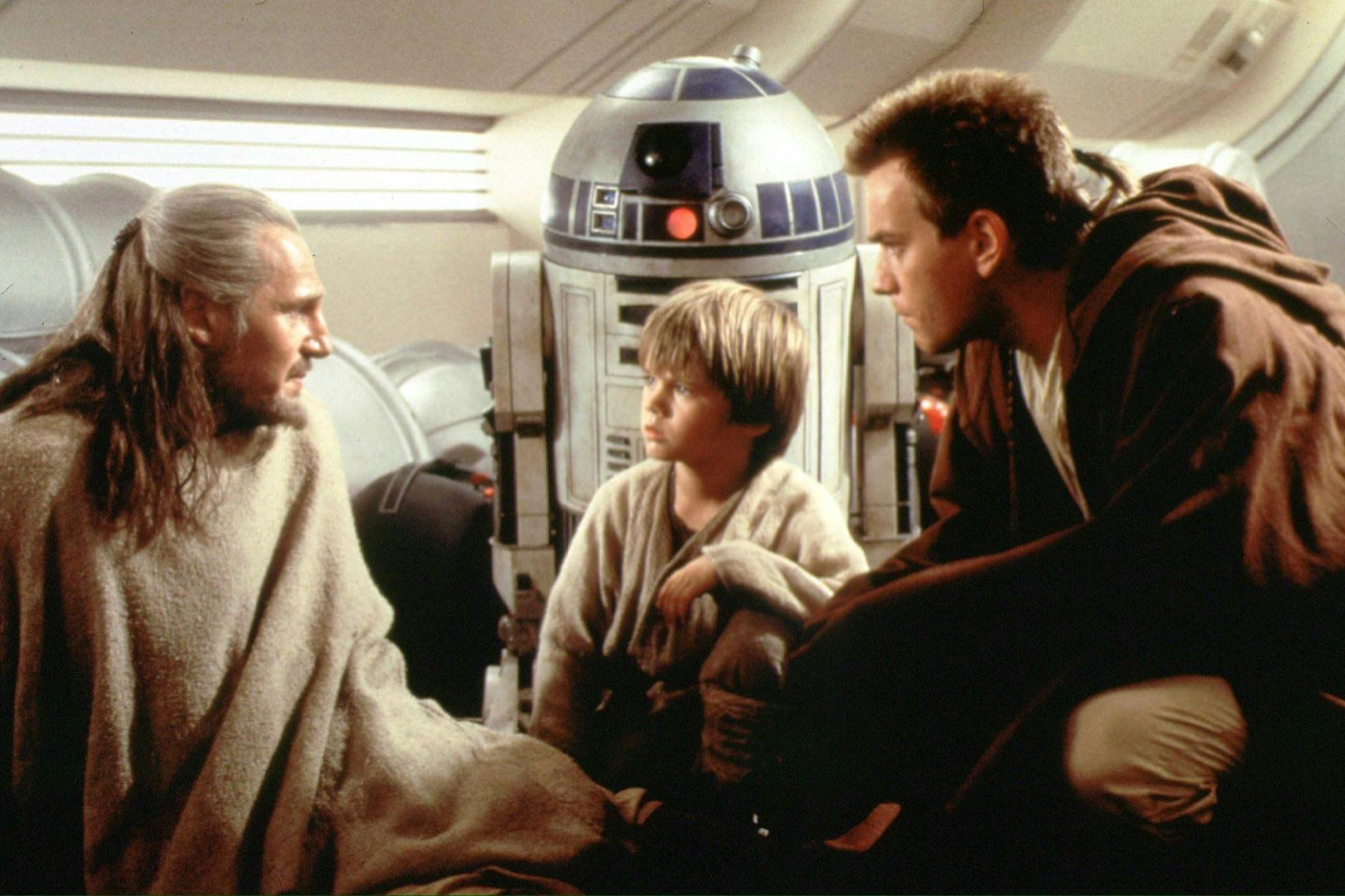 Gruppenbild mit Roboter: Jedi-Meister Qui-Gon Jinn (Liam Neeson, l.), Anakin Skywalker (Jake Loyd) und Macht-Azubi Obi-Wan Kenobi (Ewan McGregor). Hinten: R2-D2.