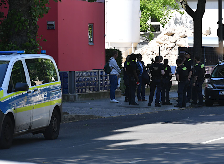 Polizeibeamte stehen in Schöneberg vor einem Wohnhaus, das am Morgen aus Sicherheitsgründen geräumt worden war.