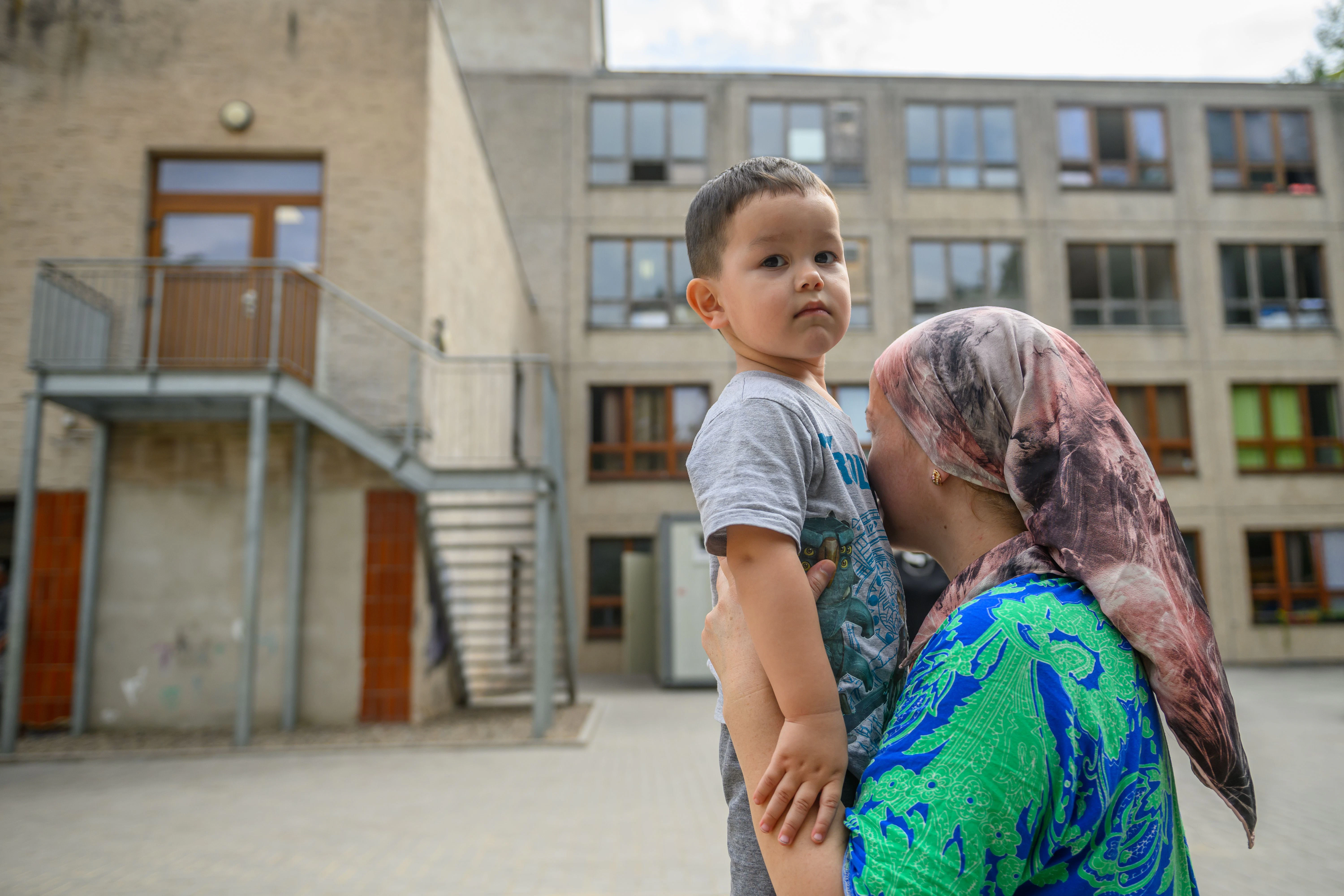 Eine tschetschenische Frau und ihr Sohn vor einer Gemeinschaftsunterkunft für Geflüchtete in Thüringen.