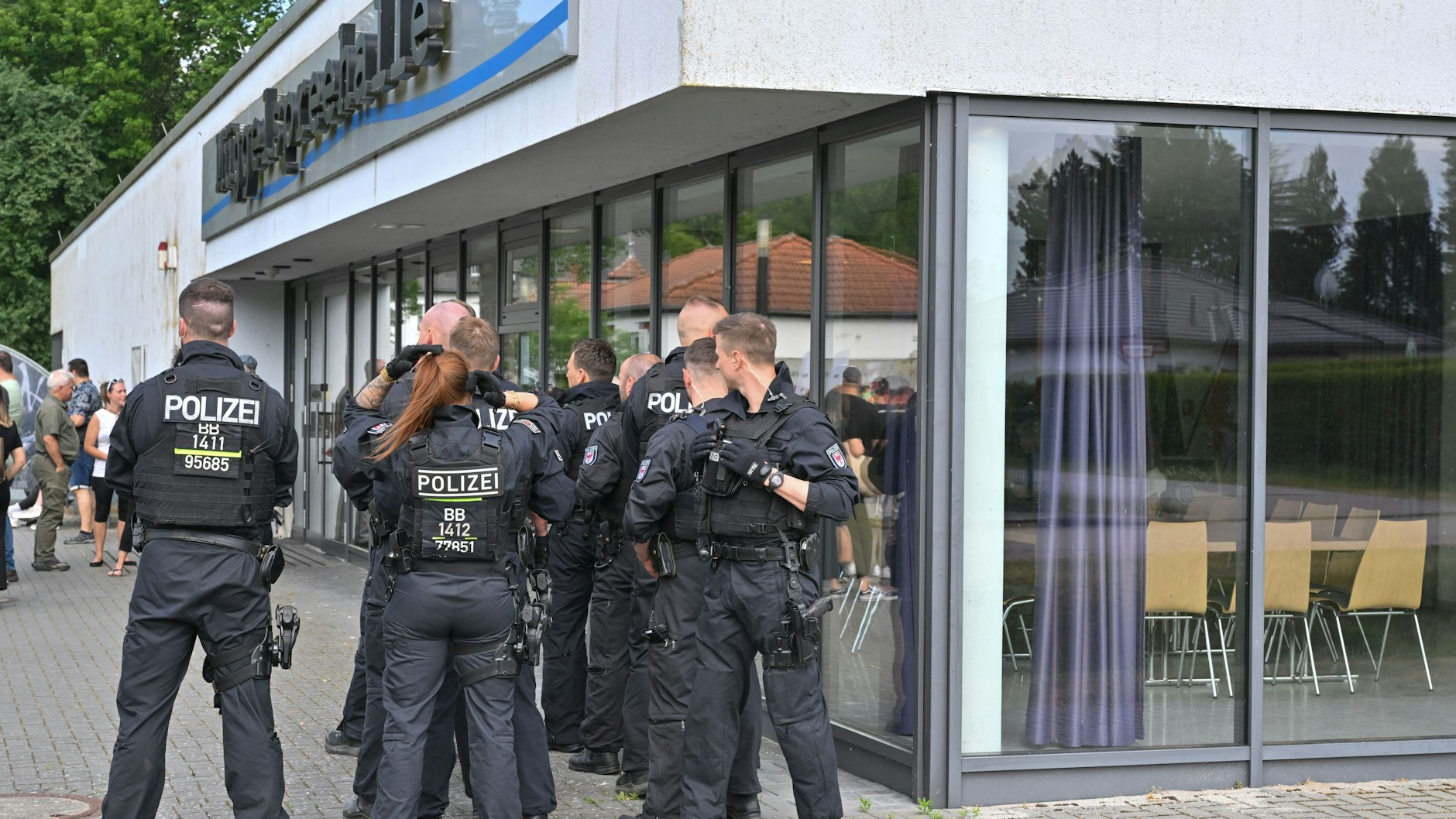 Polizeibeamte sichern die Müggelspreehalle in Hangelsberg, einem Ortsteil von Grünheide, wo die Gemeindevertreter über die Erweiterungspläne der Tesla-Fabrik in Grünheide abstimmten.