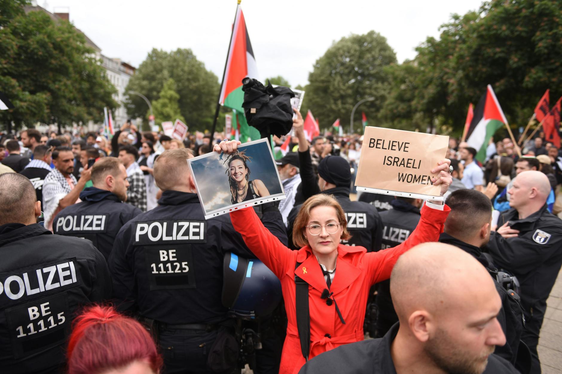 Die FDP-Politikerin Karolin Preisler hält ein Pappschild mit der Aufschrift „Believe Israeli Women“ und ein Porträt der getöteten Hamas-Geisel Shani Louk in die Höhe.