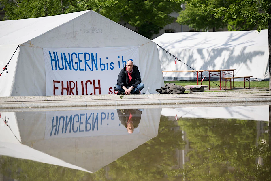 ARCHIV - Wolfgang Metzeler-Kick sitzt am neuen Standort des Hungerstreik-Camps des Bündnisses «Hungern bis ihr ehrlich seid» im Regierungsviertel vor einem Banner.  