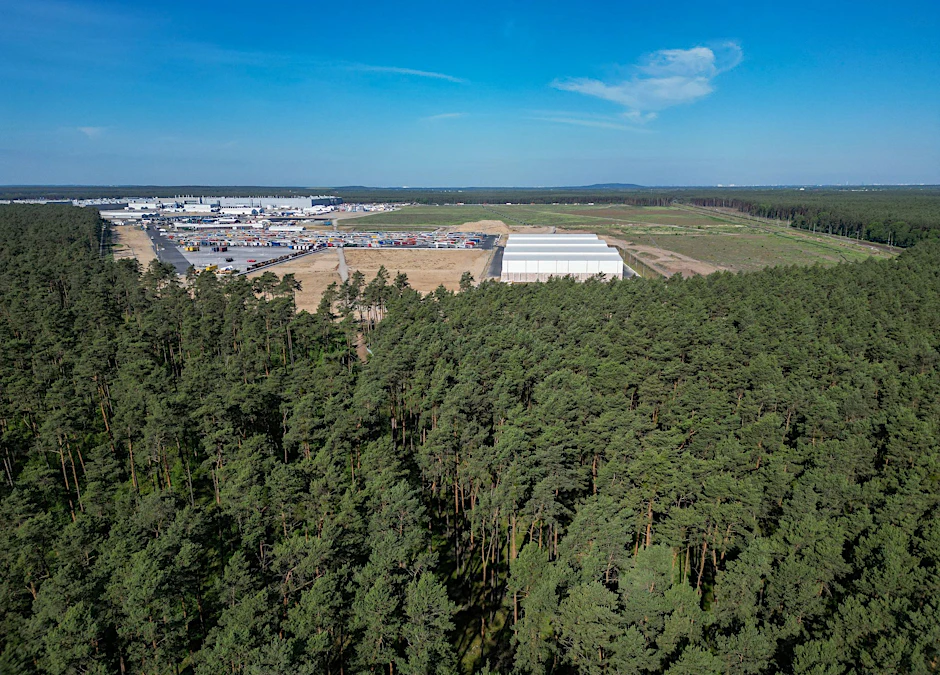 Dichter Wald steht am östlichen Teil des Werksgeländes der Tesla Gigafactory (Aufnahme mit einer Drohne).  