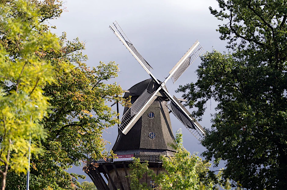ARCHIV - Dunkle Regenwolken hinter der Historischen Mühle im Park Sanssouci.  a