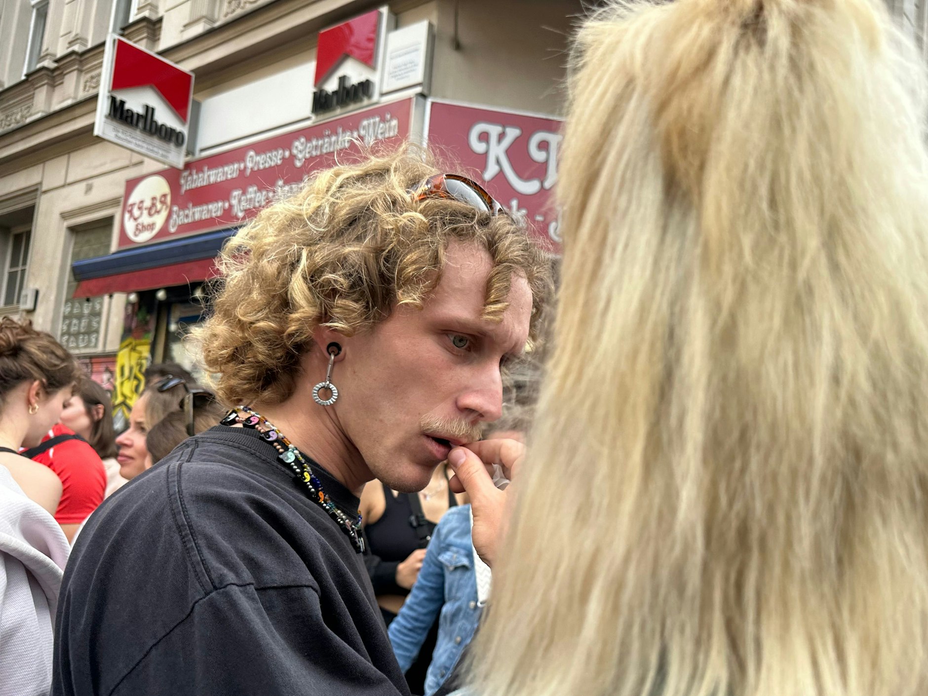 Ein interessanter Look: Korkenzieherlocken, Oberlippenbart und Tunnelohrring.