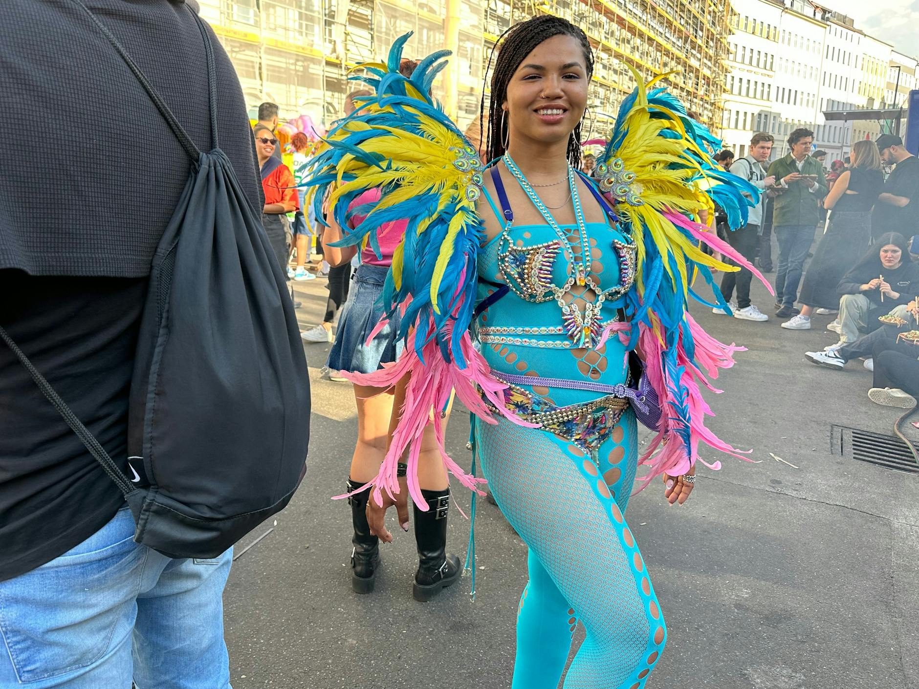 Zum Cut-Out-Body in Türkis sind die Federn an diesem Outfit seitlich drapiert.