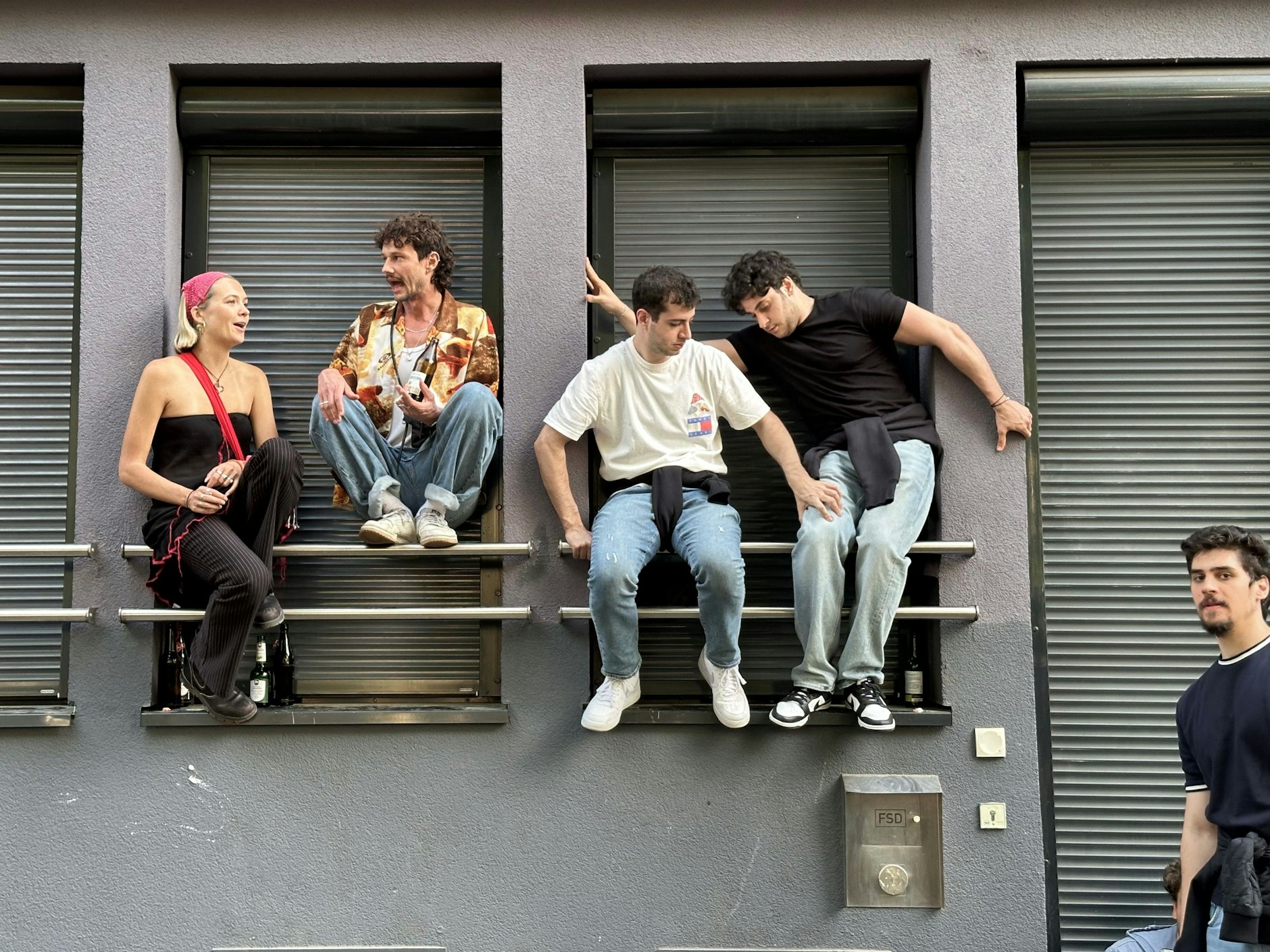 Mutige Menschen klettern auf Fenster, Schaltkästen und Laternenpfähle.  Hierbei handelt es sich um eine alte Berliner Partytradition, die ursprünglich im Rahmen der Loveparade erfunden wurde.