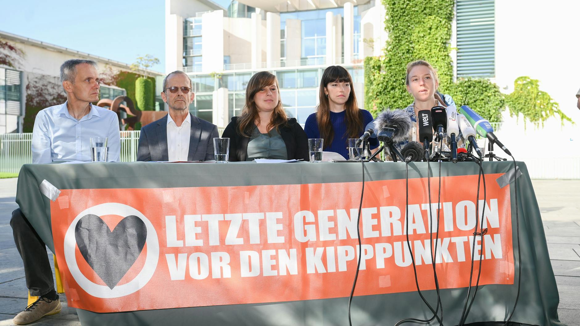 Die Aktivisten der Klimaschutzgruppe Letzte Generation Rolf Meyer, (v. l.), Nikolaus Froitzheim, Chiara Malz, Carla Hinrichs, und Lina Johnsen sitzen während eines Pressestatements in Berlin vor dem Bundeskanzleramt.