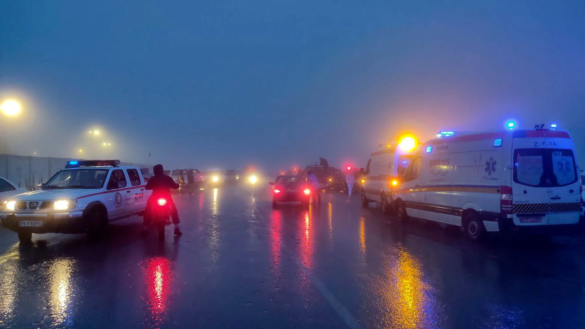 HANDOUT - Rettungsteams im iranischen Varzaghan im Einsatz: Strömender Regen und Wind erschwerten die Suche in der bergigen Region.  /dpa