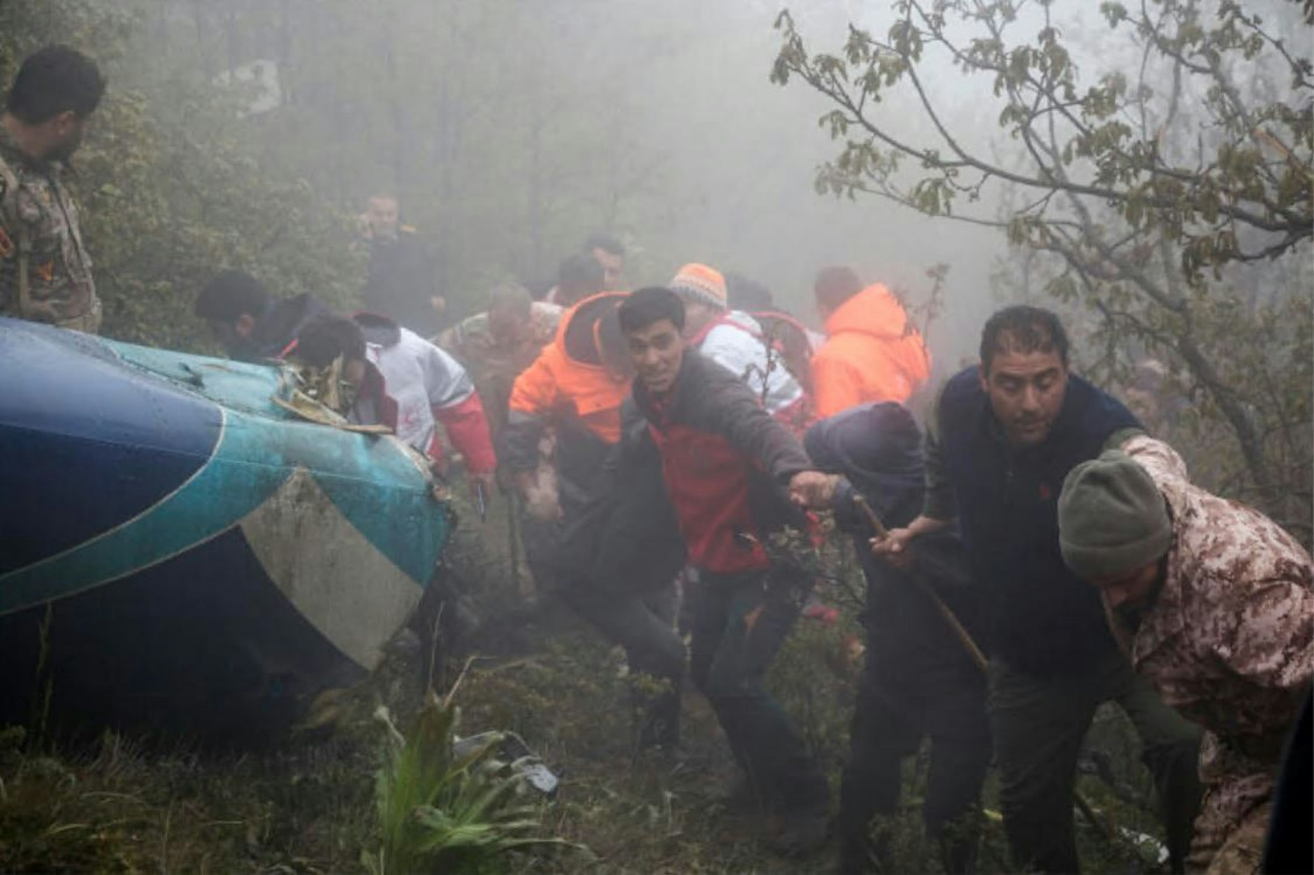 Rettungsteams bergen die Leichen aus den Trümmern des abgestürzten Helikopters.