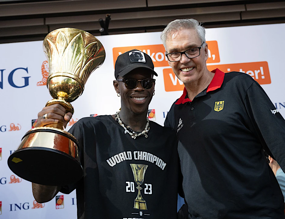 ARCHIV - Dennis Schröder (l) und Basketball-Bundestrainer Gordon Herbert mit dem WM-Pokal.  