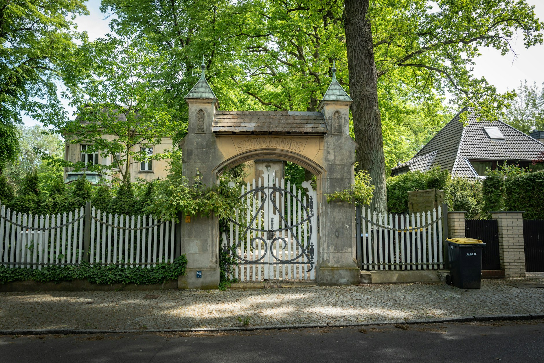 Von einem weißen, sanft geschwungenen Zaun umgeben: der Schwanenhof, von der Inselstraße aus gesehen