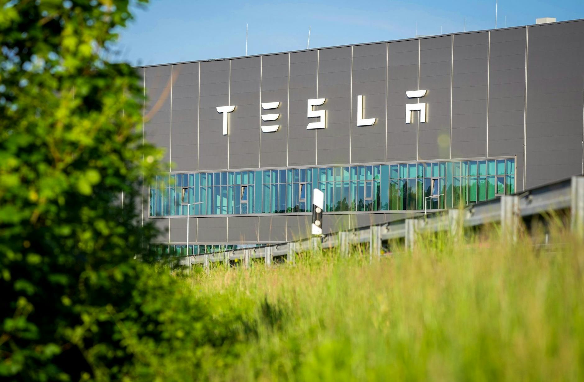 ARCHIV - Der Schriftzug "Tesla" steht an der Fassade eines Gebäudes der Tesla Gigafactory.