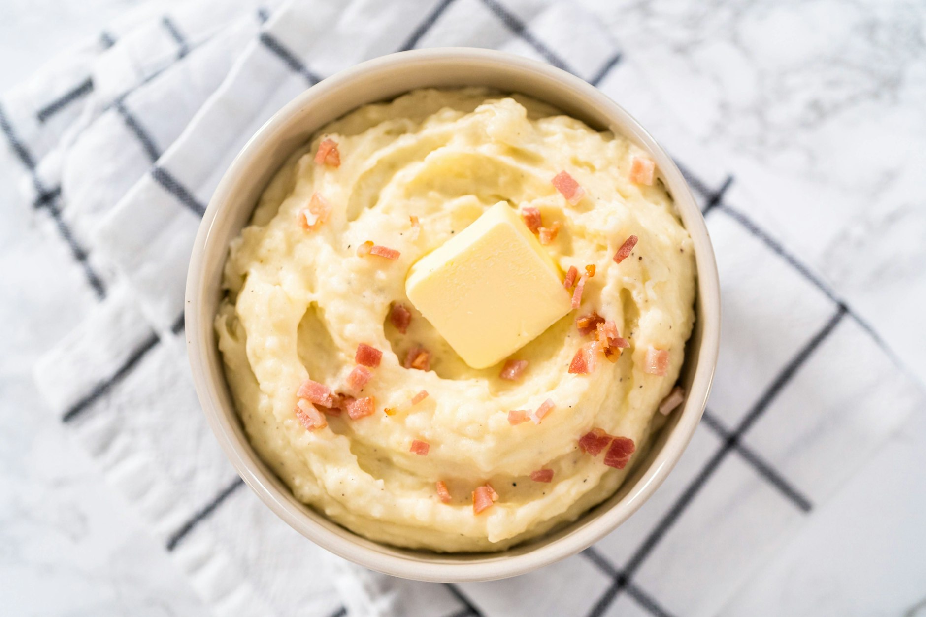 Zu einem Kartoffelstampf mit Blumenkohl und gebratenen Zwiebeln kann man auch noch einige Speckwürfel braten. Muss man aber nicht. 