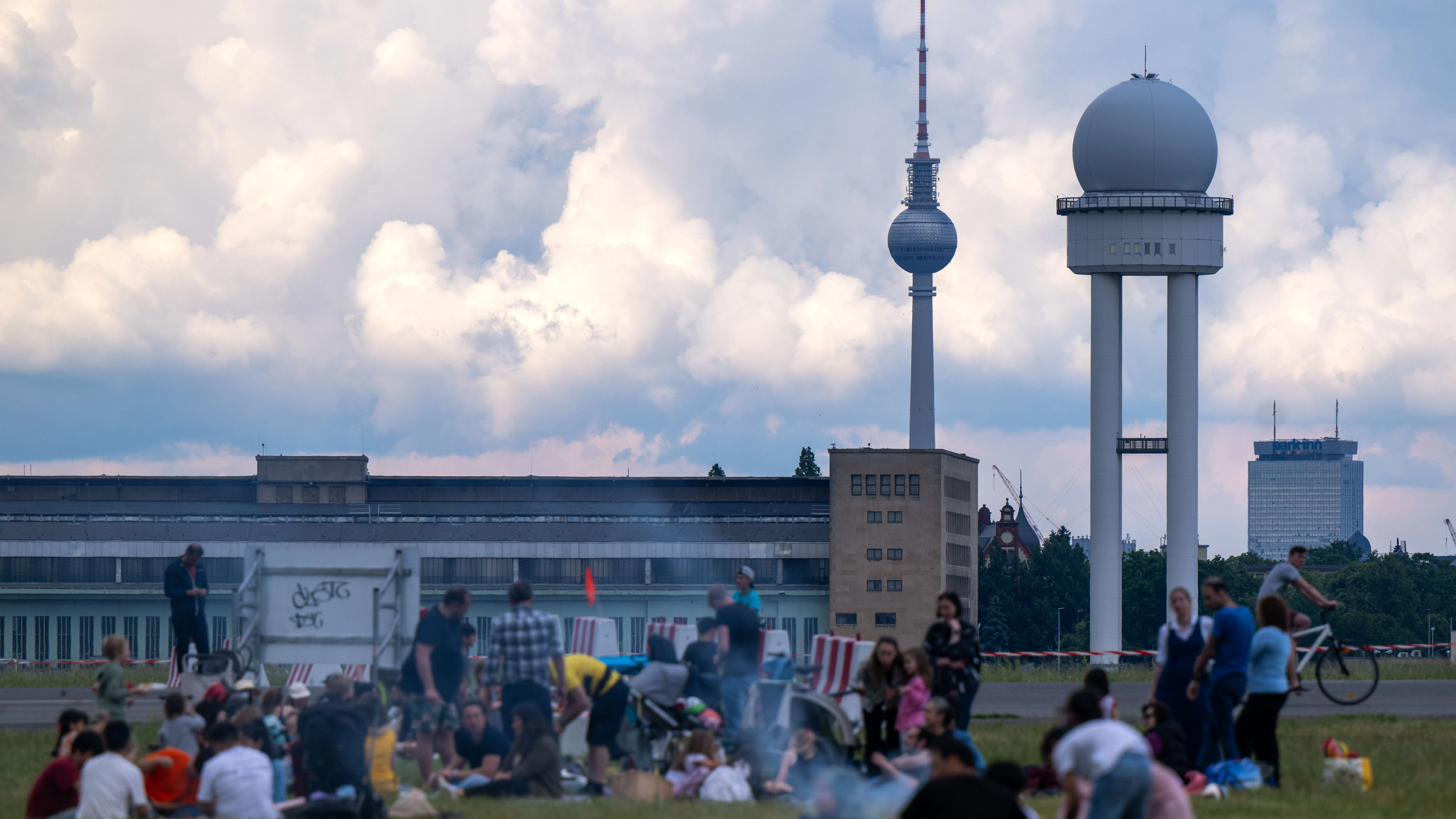 Zahlreiche Berliner grillen bei sommerlichen Temperaturen auf einem Grillplatz auf dem Tempelhofer Feld.
