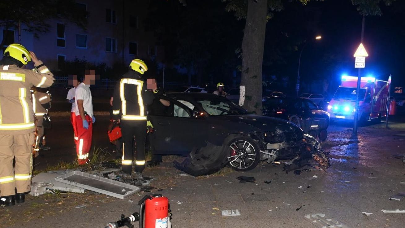 Der schwer mitgenommene BMW und die beklagenswerten Reste des Telekom-Verteilers (li.) auf dem Bürgersteig.