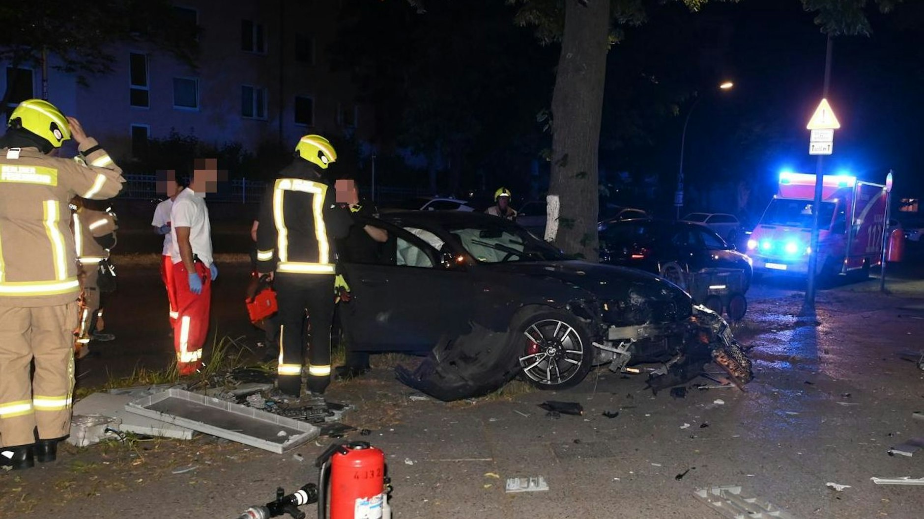 Der schwer mitgenommene BMW und die beklagenswerten Reste des Telekom-Verteilers (li.) auf dem Bürgersteig.