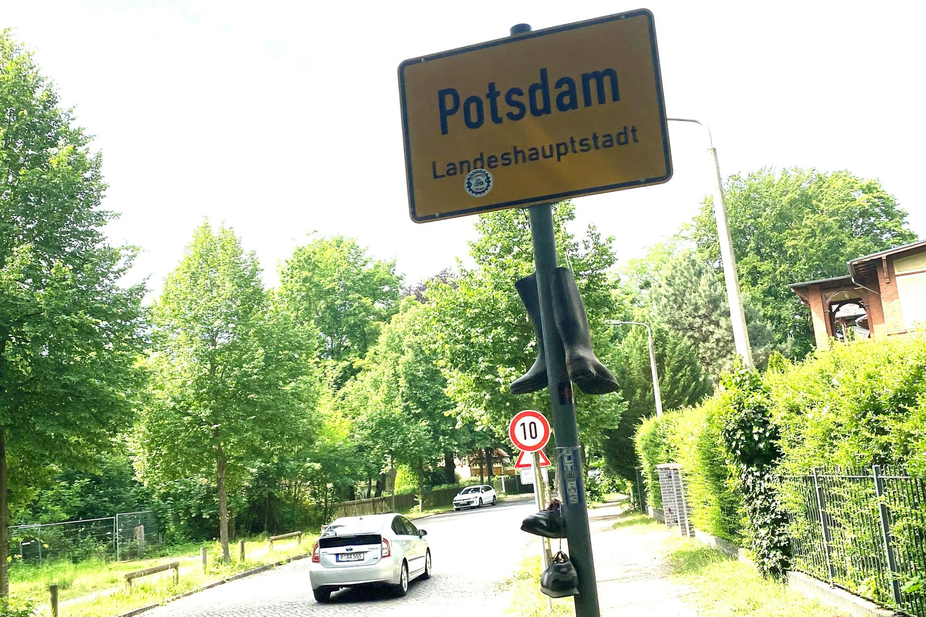 Die Einfahrt zur Rudolf-Breitscheid-Straße: Tempo 10 regiert hier neuerdings. Das Schuhwerk haben Spaßvögel ans Ortsschild gehängt.