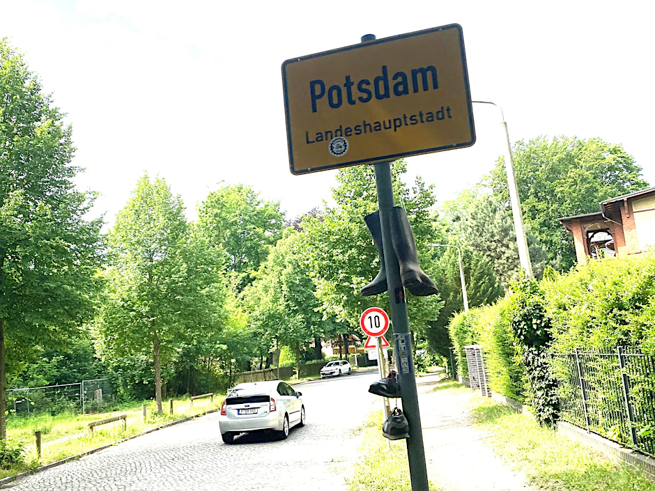 Die Einfahrt zur Rudolf-Breitscheid-Straße: Tempo 10 regiert hier neuerdings. Das Schuhwerk haben Spaßvögel ans Ortsschild gehängt.