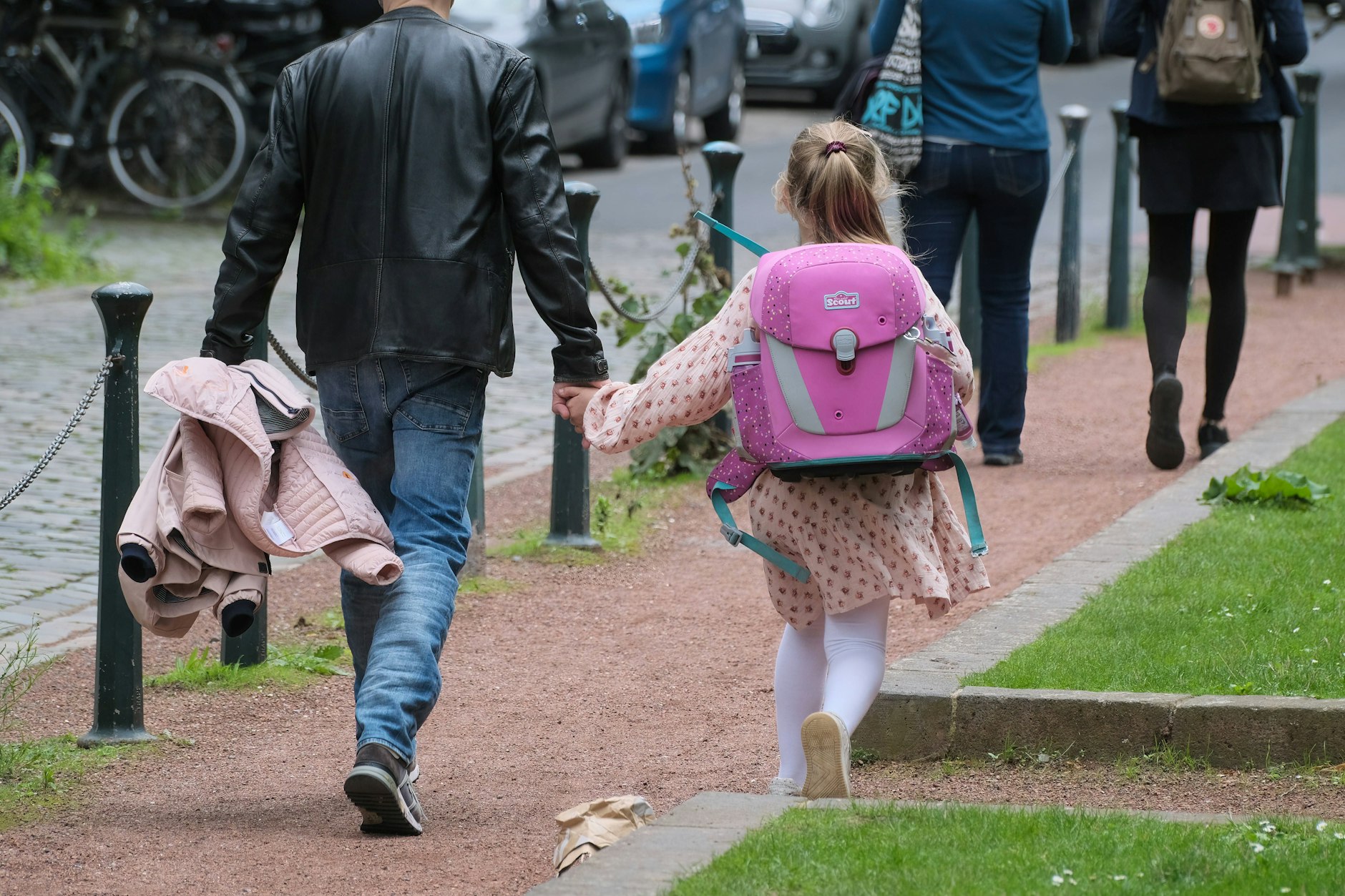 Ein Vater bringt seine Tochter zur Schule.