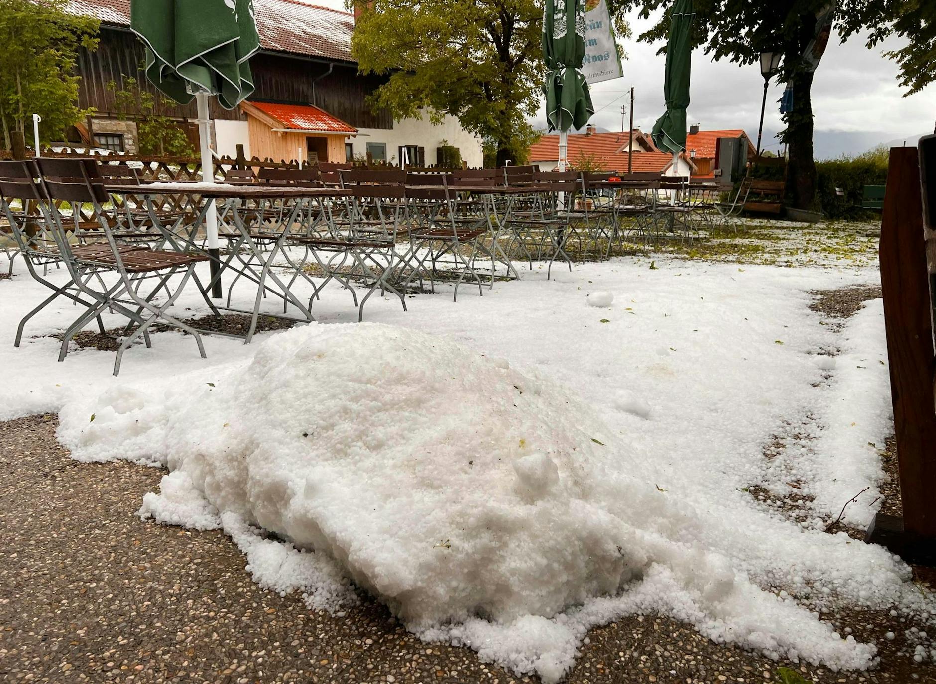 dpatopbilder - Schnee Ende Mai? Nein, das sind die Folgen eines Unwetters in Bad Tölz. Hagel liegt auf der Terrasse eines Biergartens.