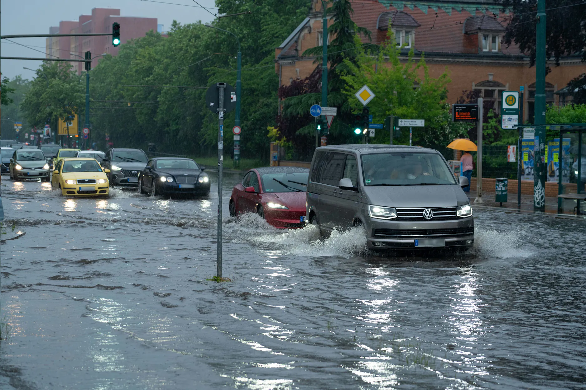 Autos fahren im Schritttempo durch die überflutete Zeppelinstraße in Potsdam. Starkregen hat sie unter Wasser gesetzt.