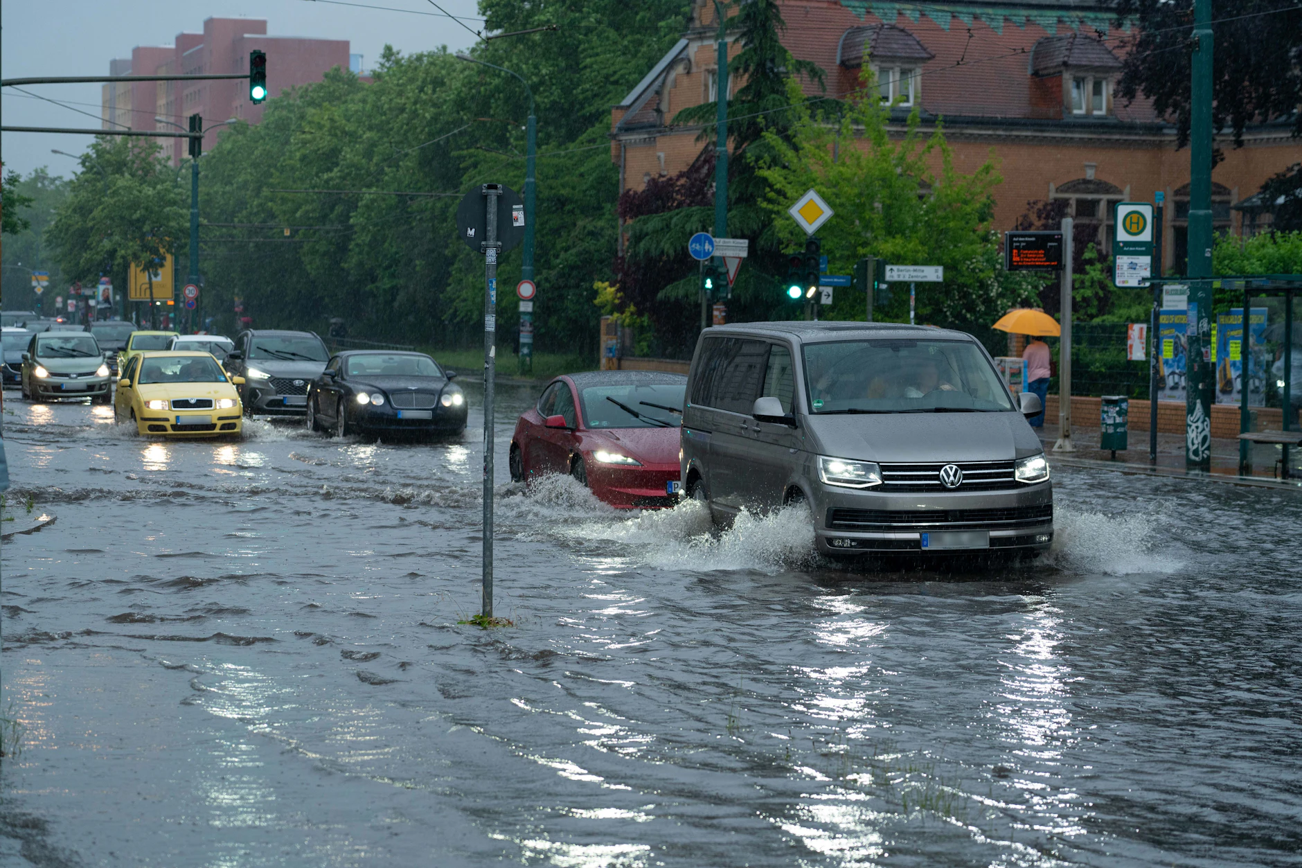 Autos fahren im Schritttempo durch die überflutete Zeppelinstraße in Potsdam. Starkregen hat sie unter Wasser gesetzt.