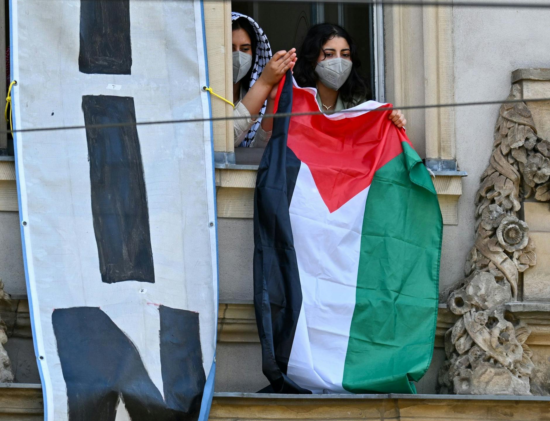 dpatopbilder - Pro-Palästinensische Demonstranten halten aus einem Fenster des Institutes für Sozialwissenschaften der Berliner Humboldt-Universität eine palästinensische Flagge. Zur Unterstützung der Palästinenser im Gazastreifen und aus Protest gegen Israel haben sie Räume der Uni besetzt.