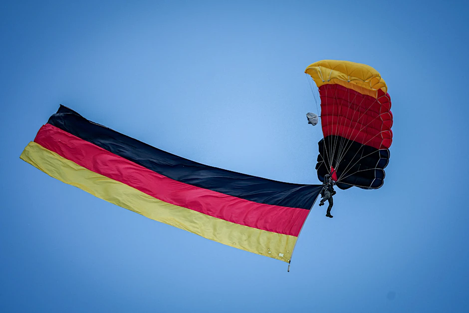 Feier zu 75 Jahre Grundgesetz: : ein Gleitschirmspringer mit der deutschen Flagge.