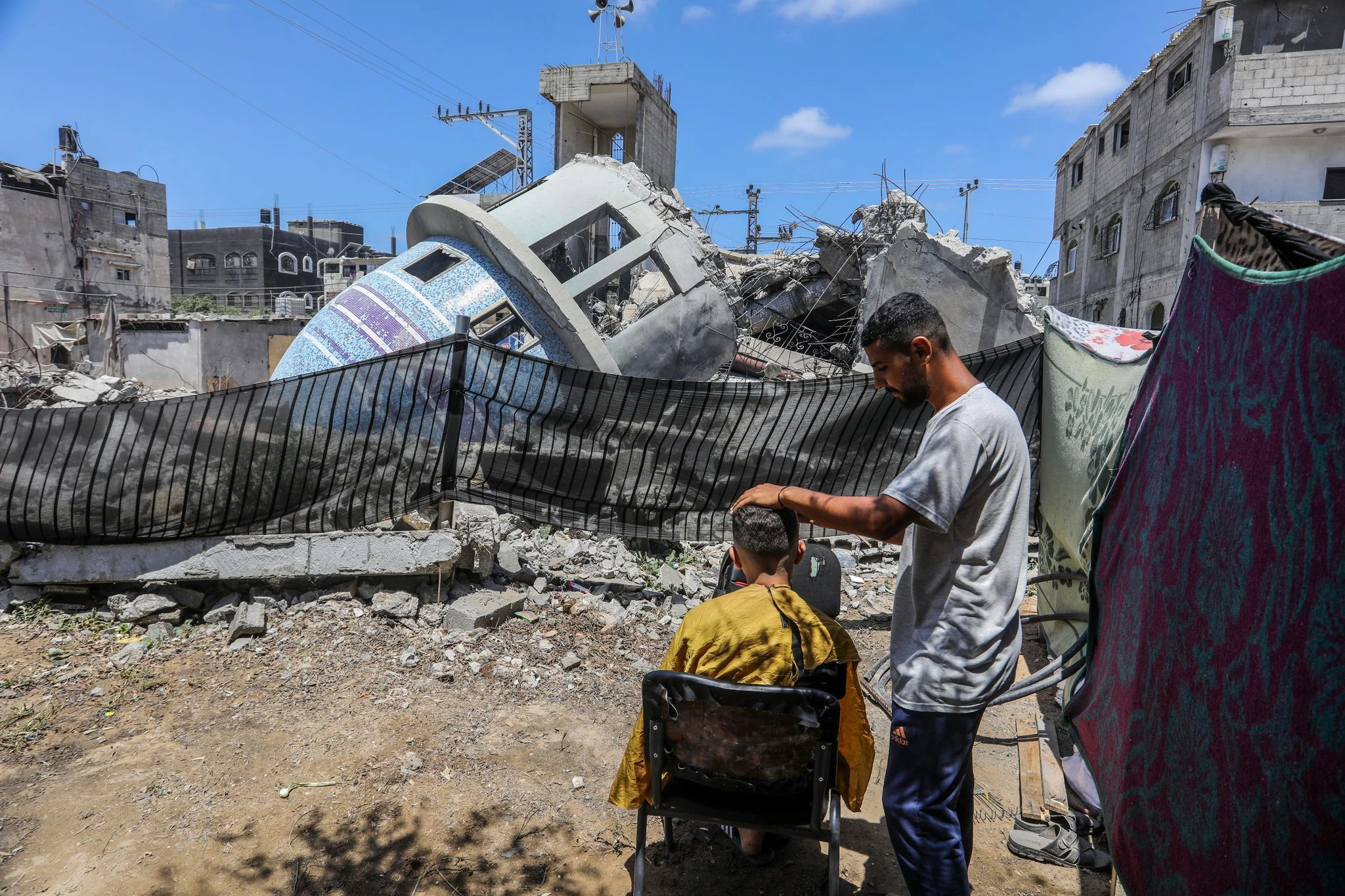 Ein Stückchen Normalität: Ein Friseur arbeitet neben einer zerstörten Moschee nach einem israelischen Luftangriff auf die Stadt Deir al-Balah im Gaza-Streifen.  