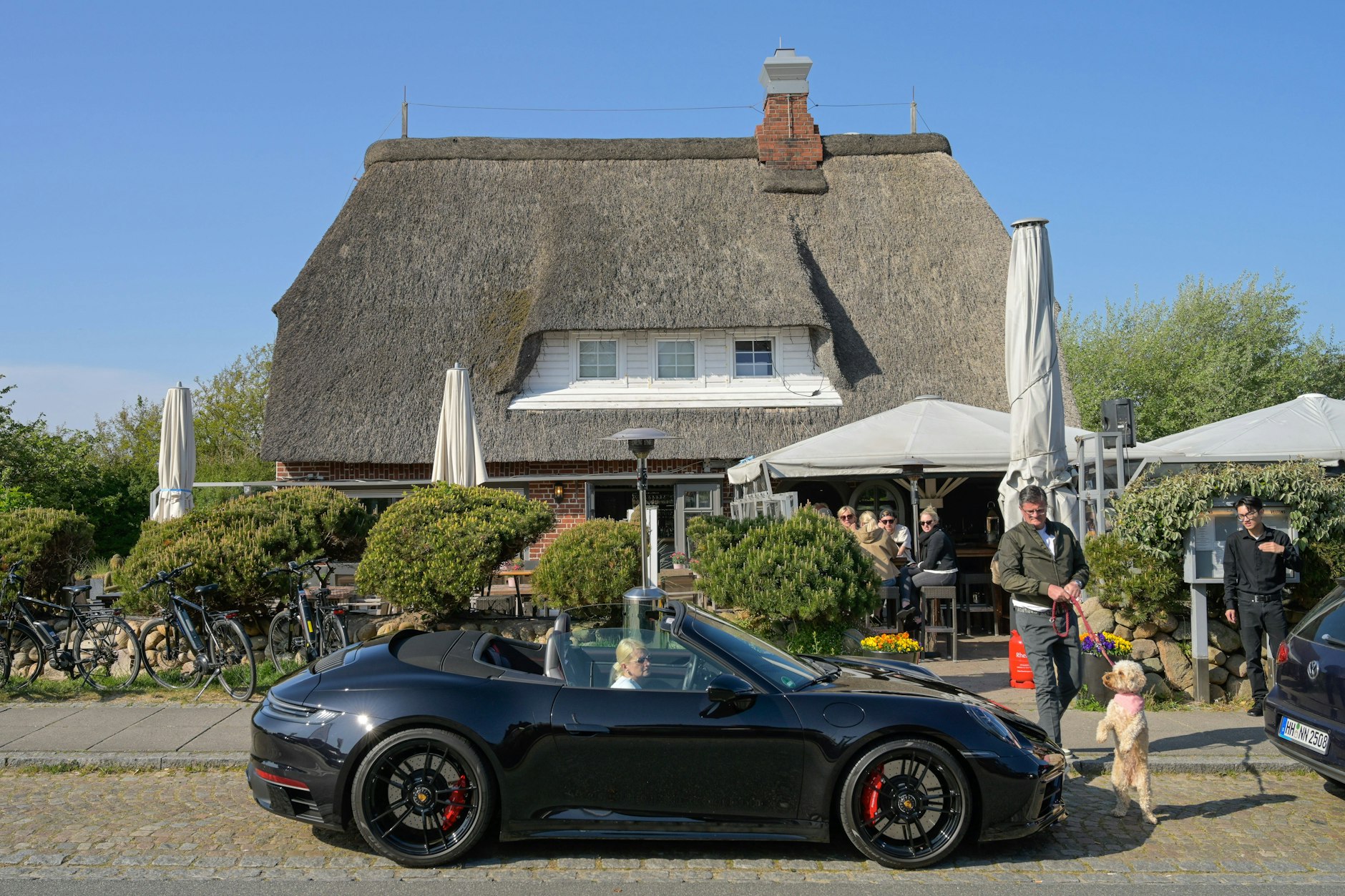Blauer Himmel, schnelle Autos, reetgedeckte Dächer: Sylt ist ein beliebtes Ferienziel.