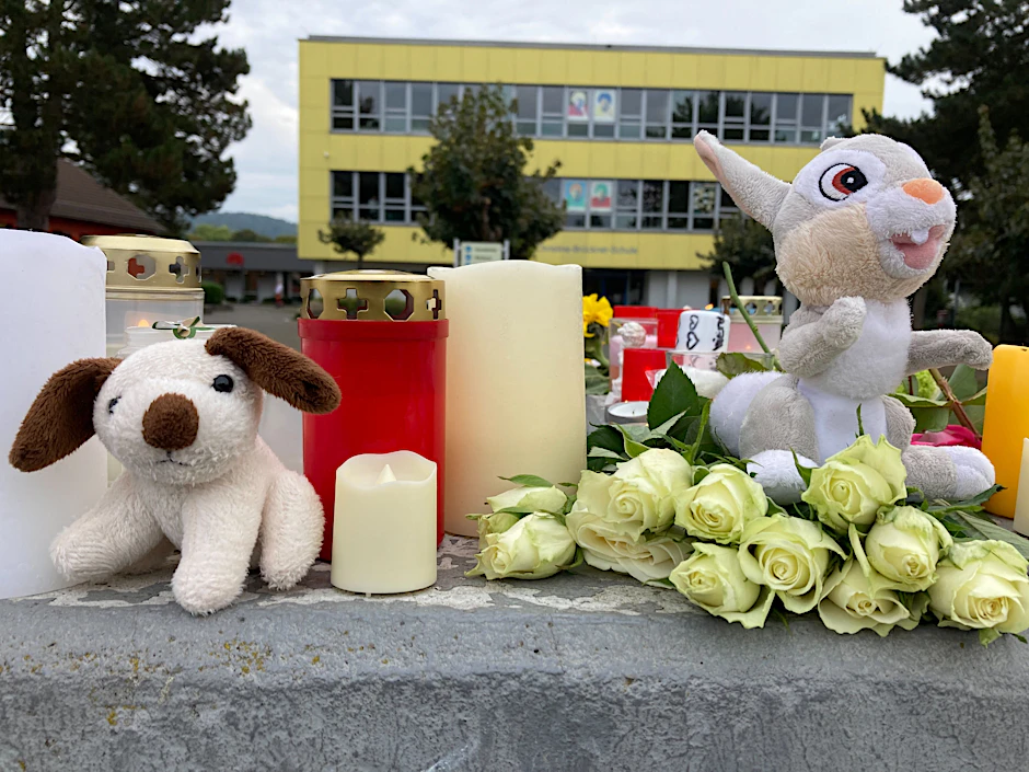 Kerzen, Blumen und Stofftiere stehen vor einer Schule in Bad Emstal (Hessen).