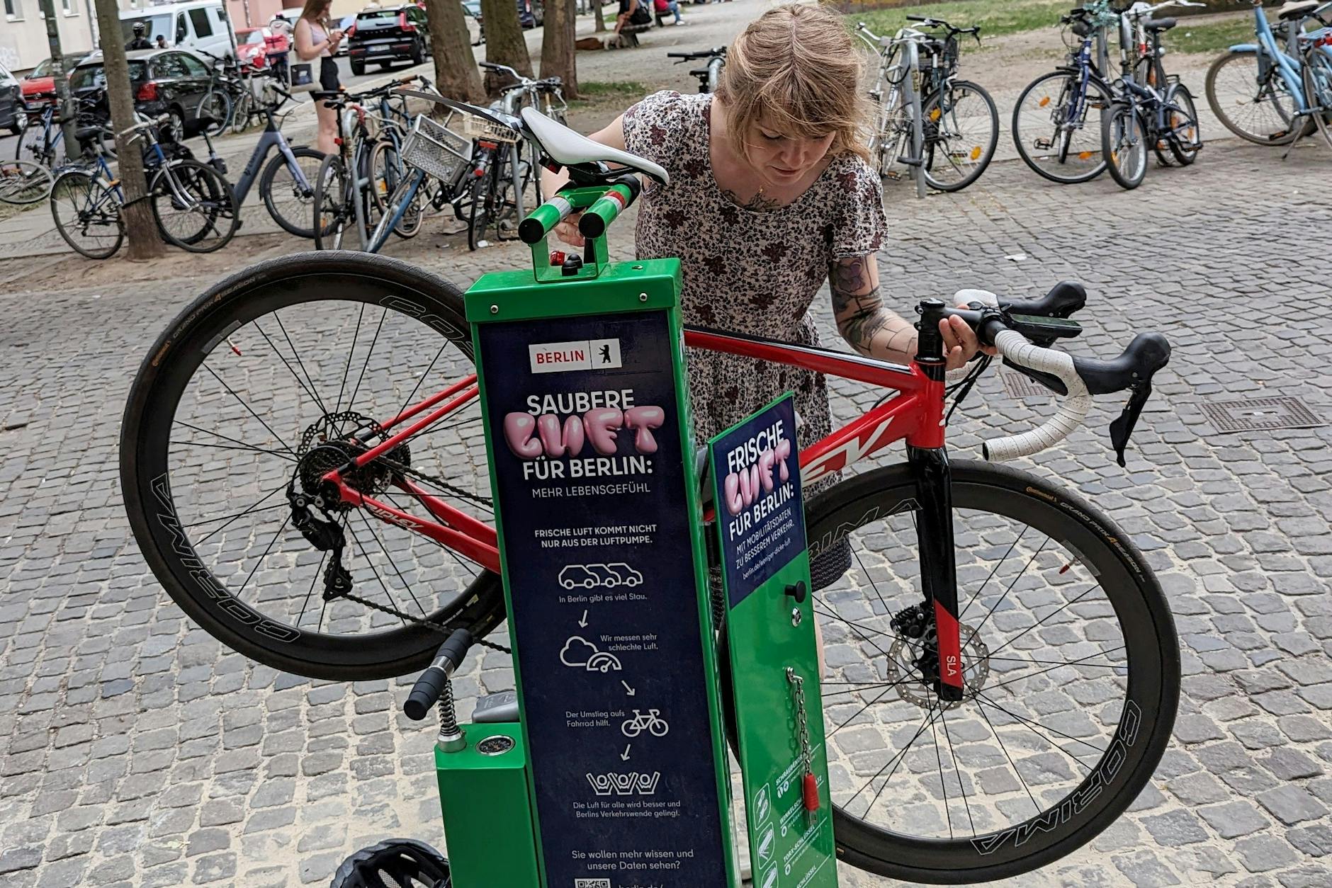 Was ist grün und steht neuerdings in der Linienstraße? Unsere Autorin und ihr Fahrrad an einer der neuen Berliner Fahrradreparaturstationen