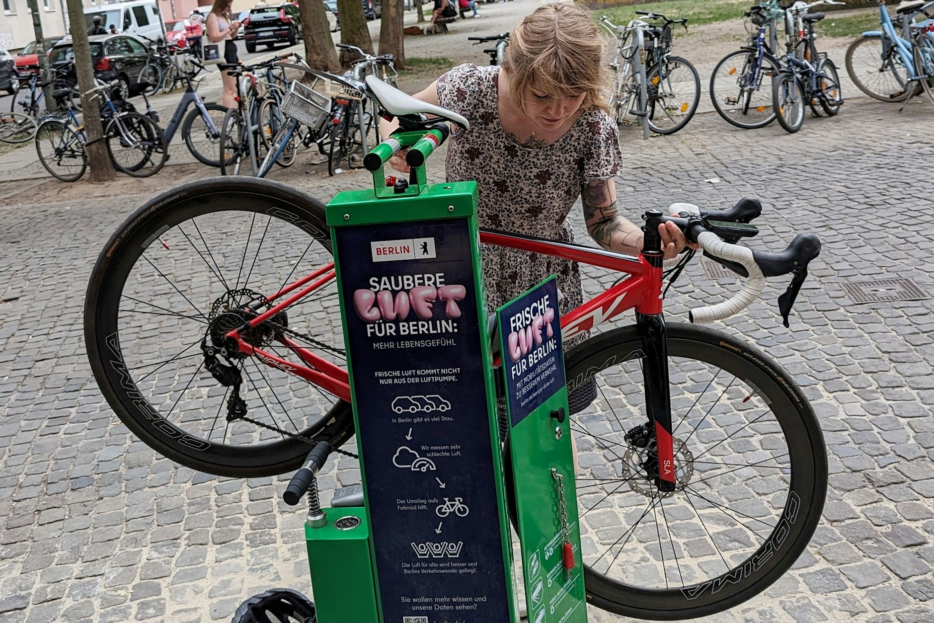 Was ist grün und steht neuerdings in der Linienstraße? Unsere Autorin und ihr Fahrrad an einer der neuen Berliner Fahrradreparaturstationen