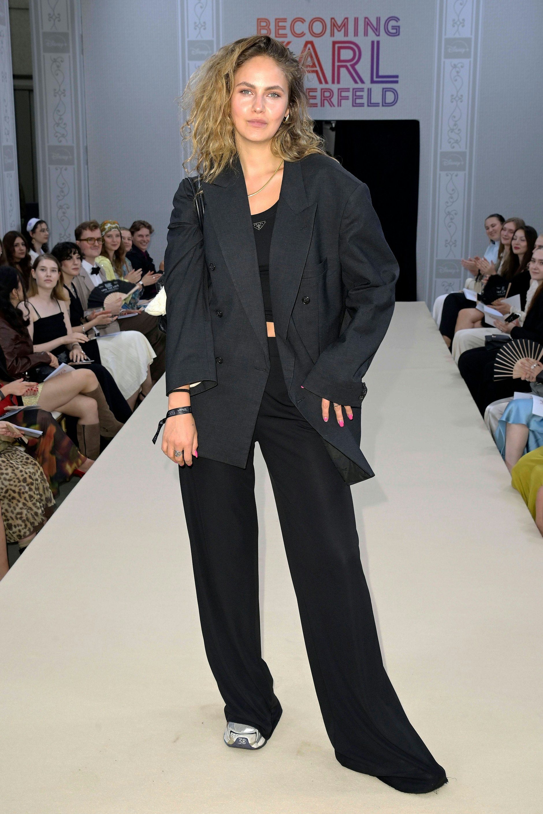 <strong>TOP:</strong> Der eine oder die andere dürfte die Sneaker als Fauxpas betrachten – wir aber finden, sie geben dem ohnehin schon herrlich lässigen Look von <strong>Elena Carrière</strong>, bestehend aus einer weiten Hose, einem Prada-Tanktop und einem kantigen Jackett, den letzten Kick. Bei <a href="https://www.berliner-zeitung.de/topics/heidi-klum">Heidi Klum</a> dürfte die ehemalige GNTM-Kandidatin solch nonchalante Modekniffe kaum gelernt haben, schließlich zeichnet sich diese eher durch überspannte Hauptsache-nackig-Outfits aus. Andererseits – woher sollte Klum es auch können? „Die war nie in Paris, die kennen wir nicht“, hatte Lagerfeld selbst mal über sie gesagt. Elena Carrière allerdings war bestimmt schon mal dort.