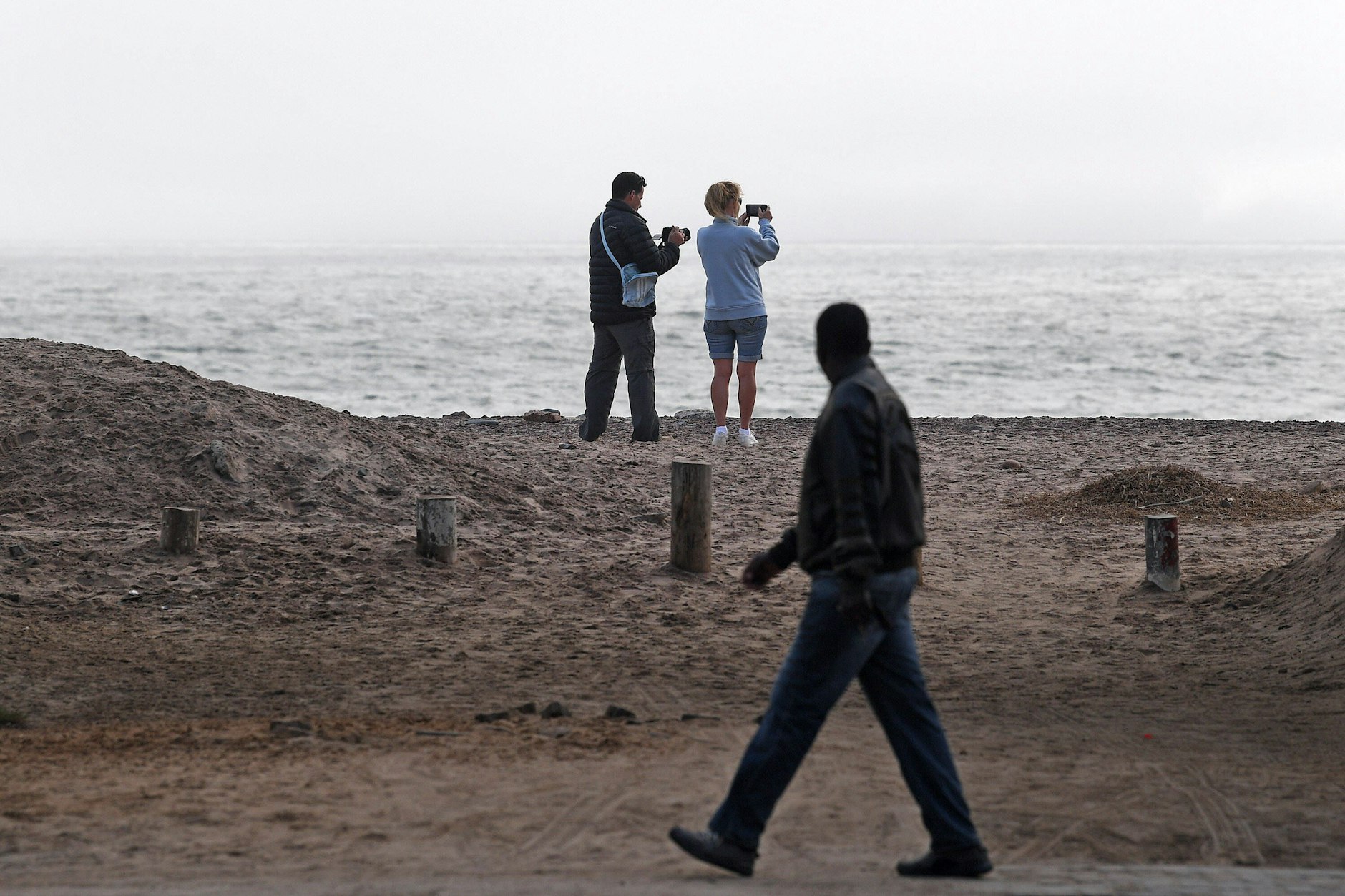 Touristen stehen an der Küste in Swakopmund.