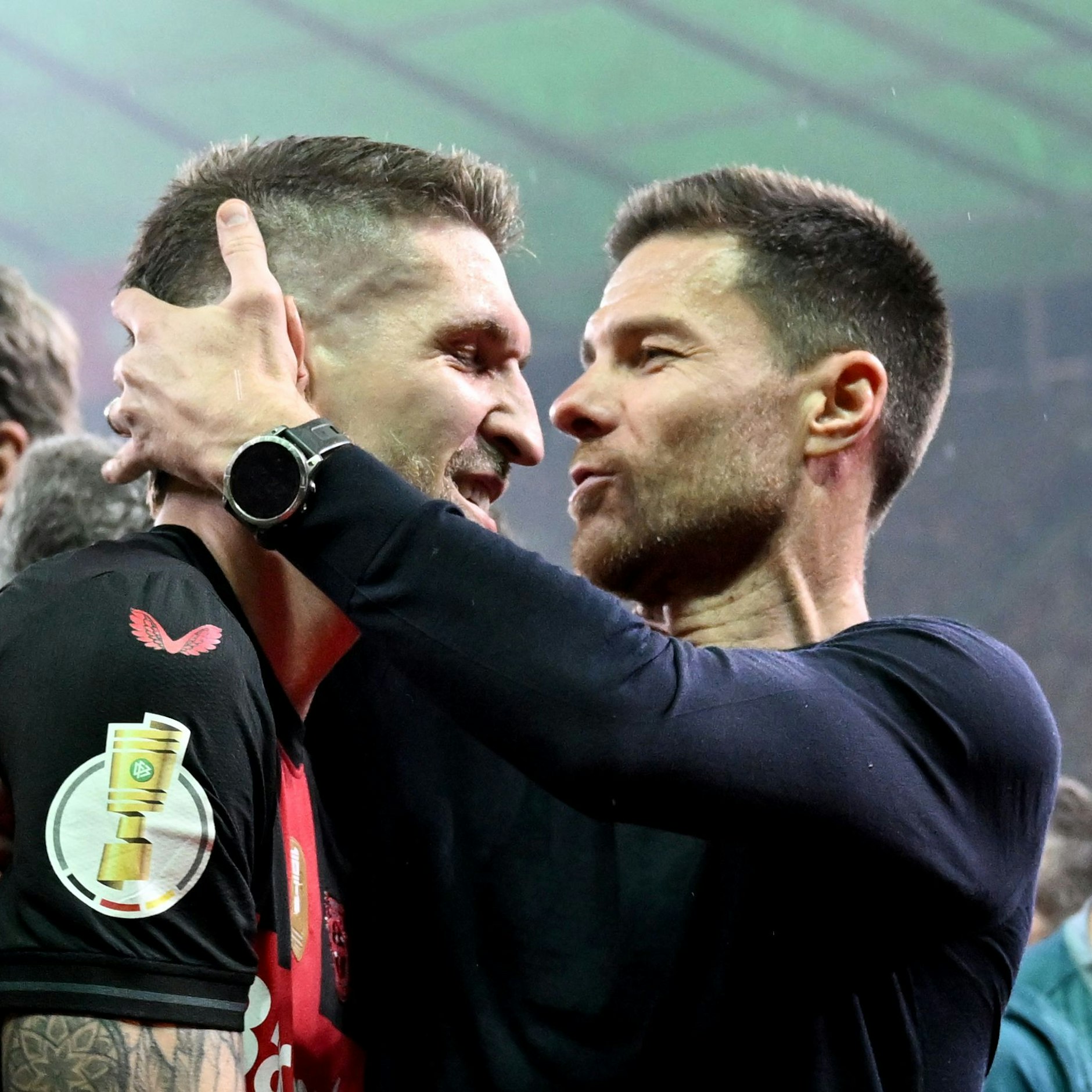Gleich drückt Leverkusen-Trainer Xabi Alonso (r.) Robert Andrich einen Schmatz auf die Wange.