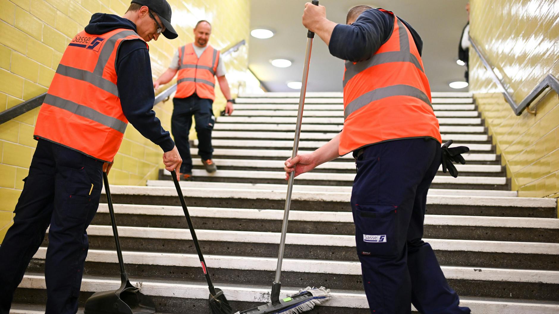 Reinigungskräfte arbeiten auf einer Treppe in der U-Bahn-Line 8. 