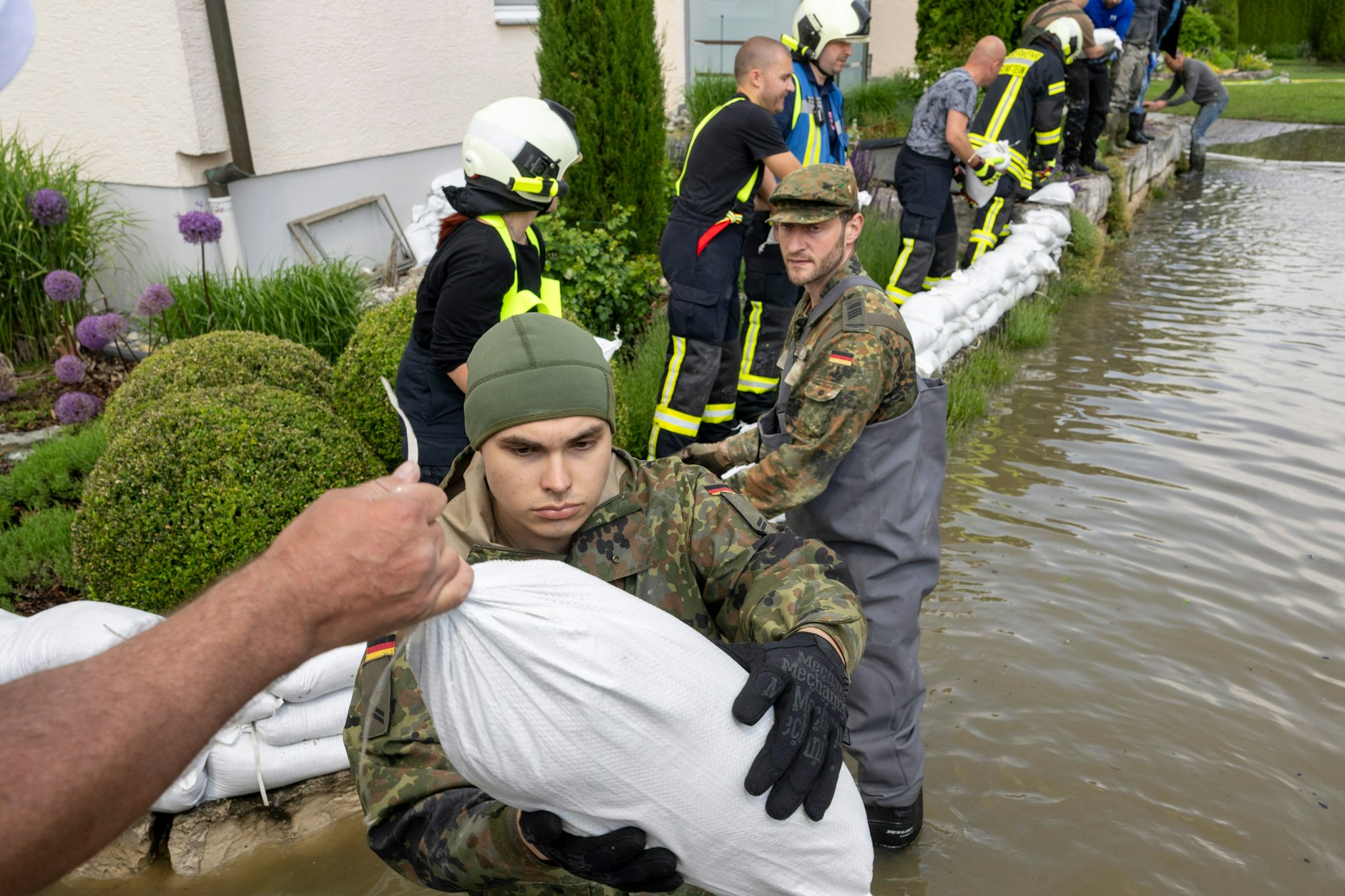 Gundelfingen: Soldaten der Bundeswehr errichten gemeinsam mit zivilen Feuerwehrkräften eine Barriere aus Sandsäcken.