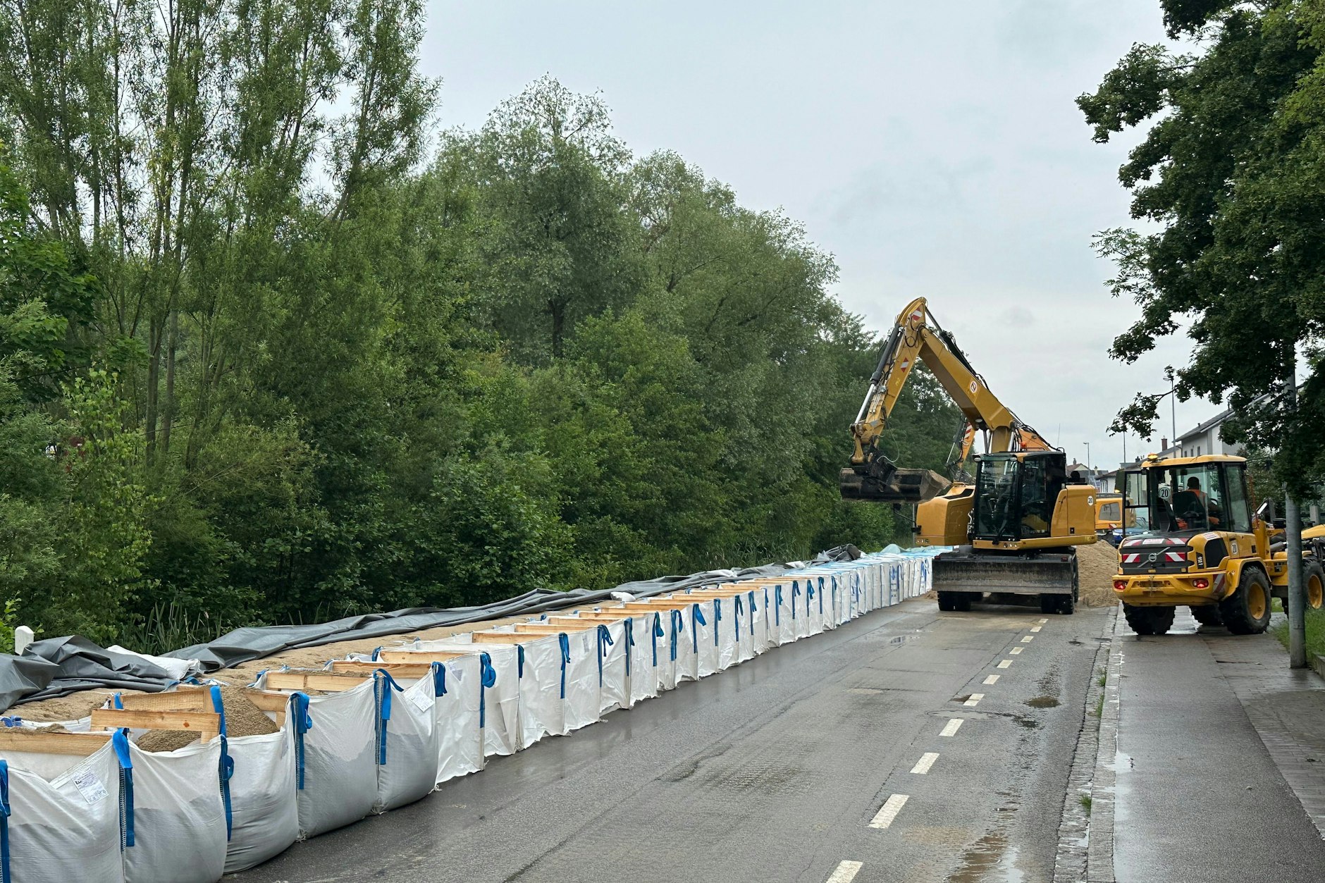 In Straubing schützen städtische Mitarbeiter eine Wohnsiedlung an der Donau mit Sandsäcken.
