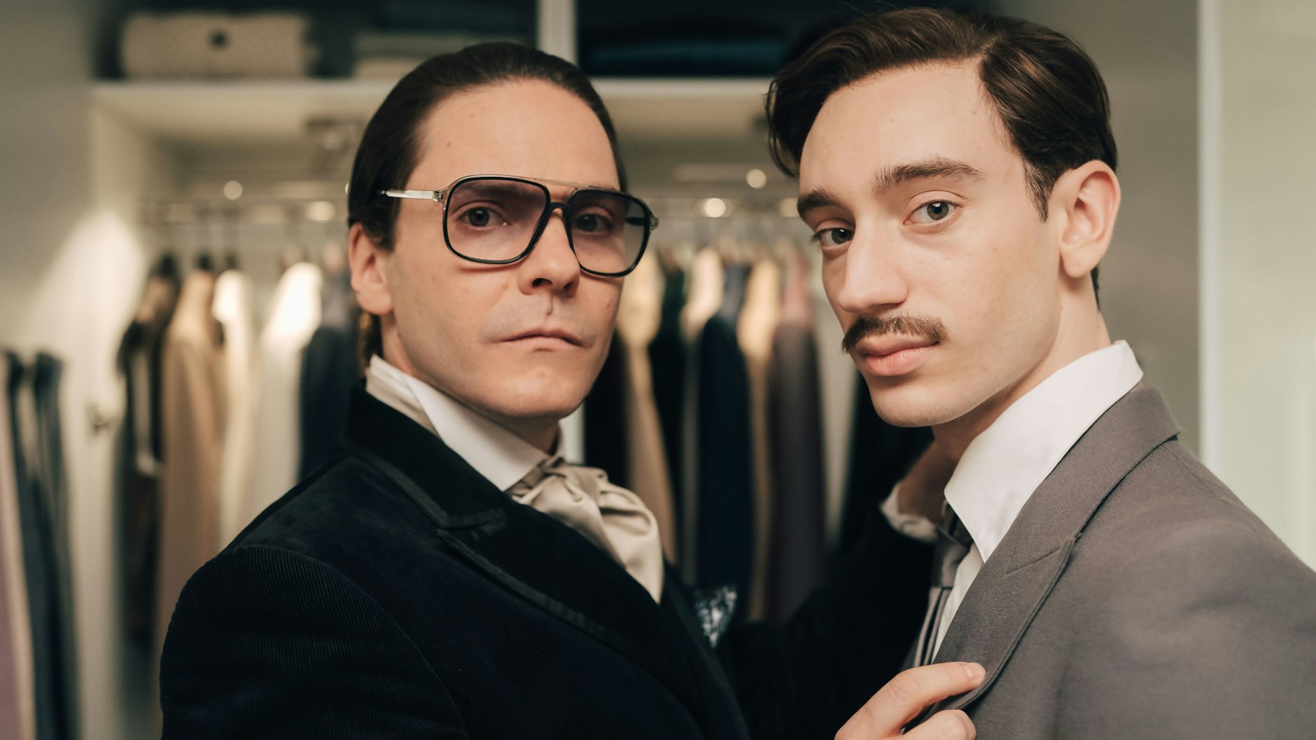 Daniel Brühl als Karl Lagerfeld und Théodore Pellerin (r.) als dessen Liebhaber Jacques de Bascher in der Miniserie „Becoming Karl Lagerfeld“ von Disney+
