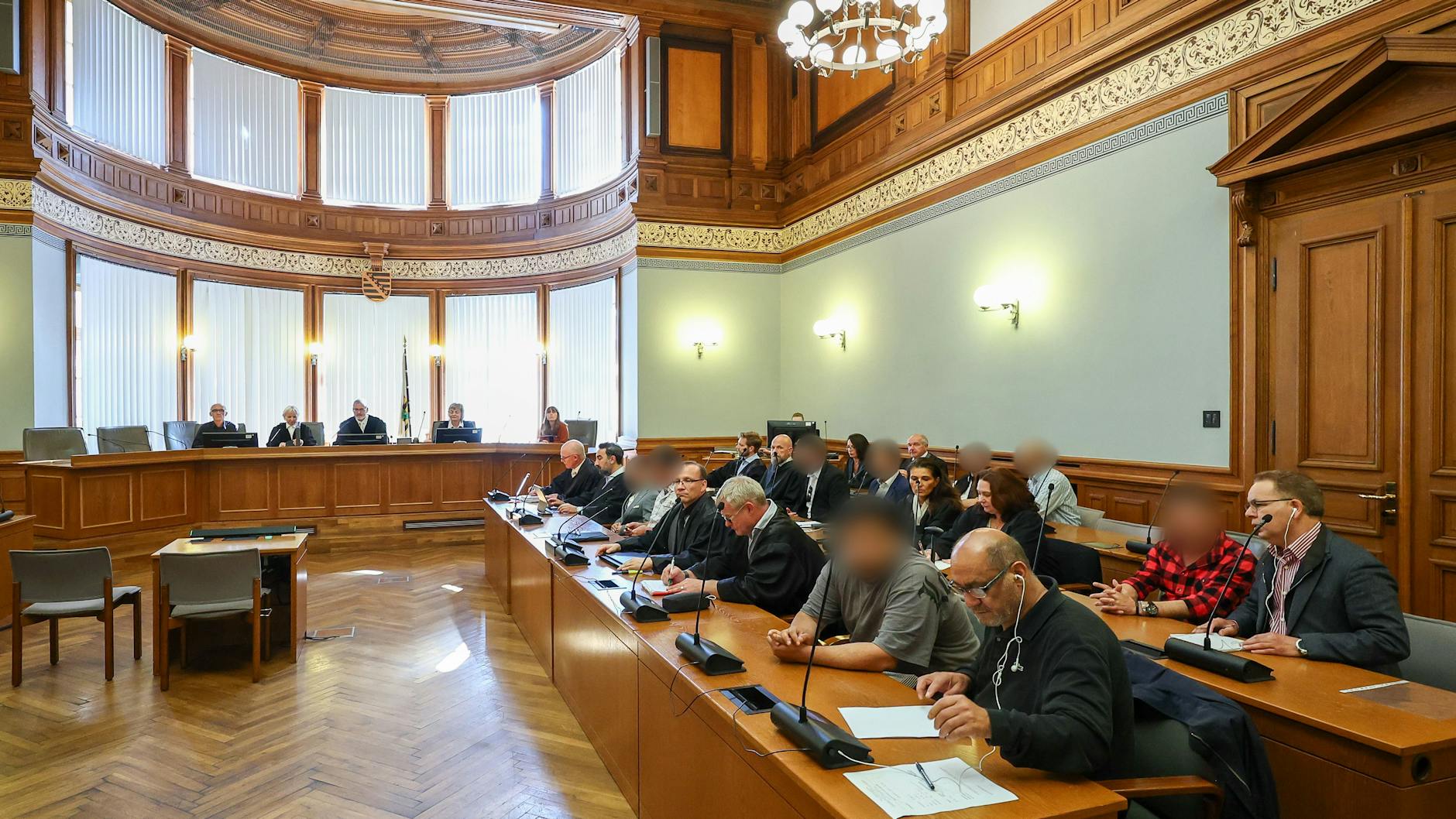 Mehrere Angeklagte einer syrischen Familie stehen mit ihren Verteidigern und Dolmetschern im Prozess um die Entführung eines angeblichen Voodoo-Zauberers im Landgericht. 