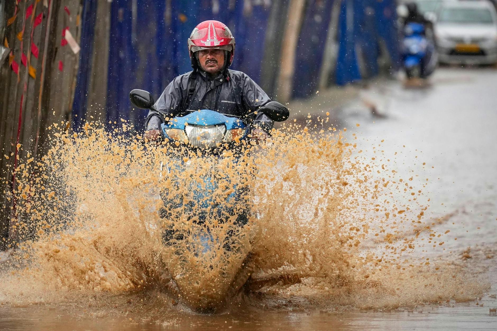 Ein Mann bahnt sich in Guwahati, Indien, den Weg durch die Überflutungen nach schweren Monsunregenfällen.
