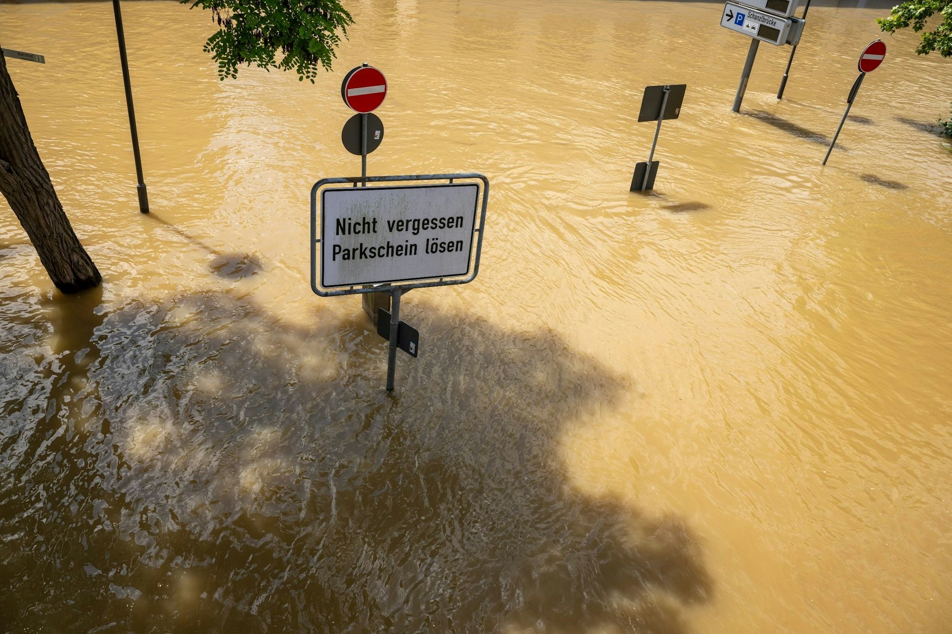 In Bayern herrscht nach heftigen Regenfällen vielerorts weiter Hochwasser. Ein Schild mit der Aufschrift "Nicht vergessen, Parkschein lösen" in Passau deutet auf einer überfluteten Parkplatz hin.  